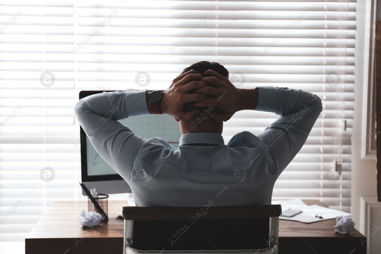 Photo of Businessman stressing out at workplace in office, back view