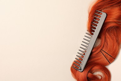 Photo of Comb with red hair strand on light background, top view. Space for text