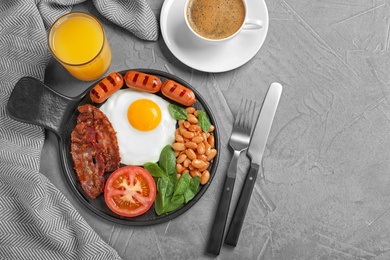 Photo of Delicious breakfast with fried egg served on grey table, flat lay. Space for text