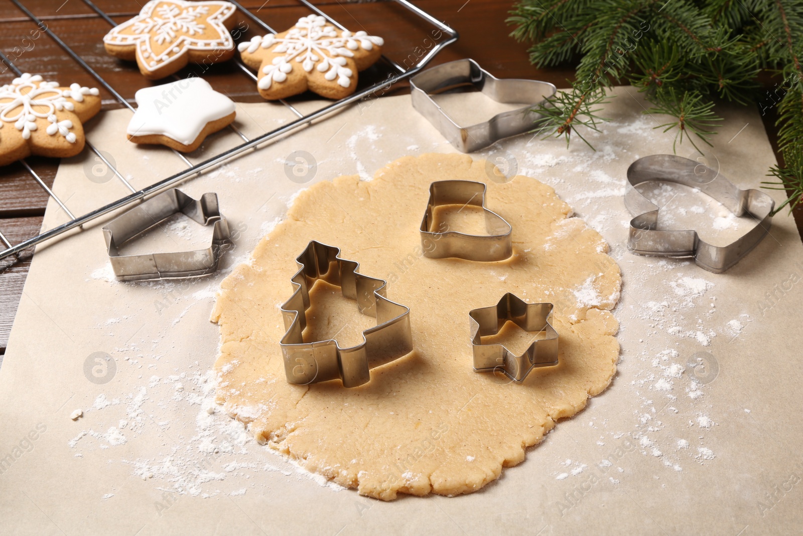 Photo of Making Christmas cookies. Raw dough and different metal cutters on table