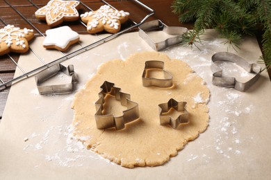 Photo of Making Christmas cookies. Raw dough and different metal cutters on table