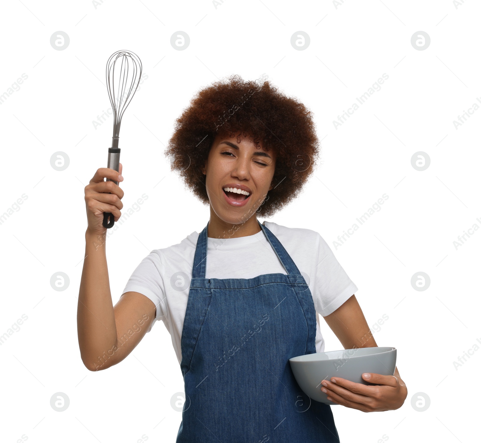 Photo of Emotional young woman in apron holding bowl and whisk on white background