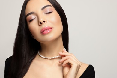 Portrait of beautiful young woman on light grey background