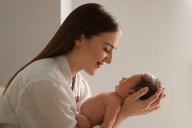 Photo of Mother holding her cute newborn baby indoors