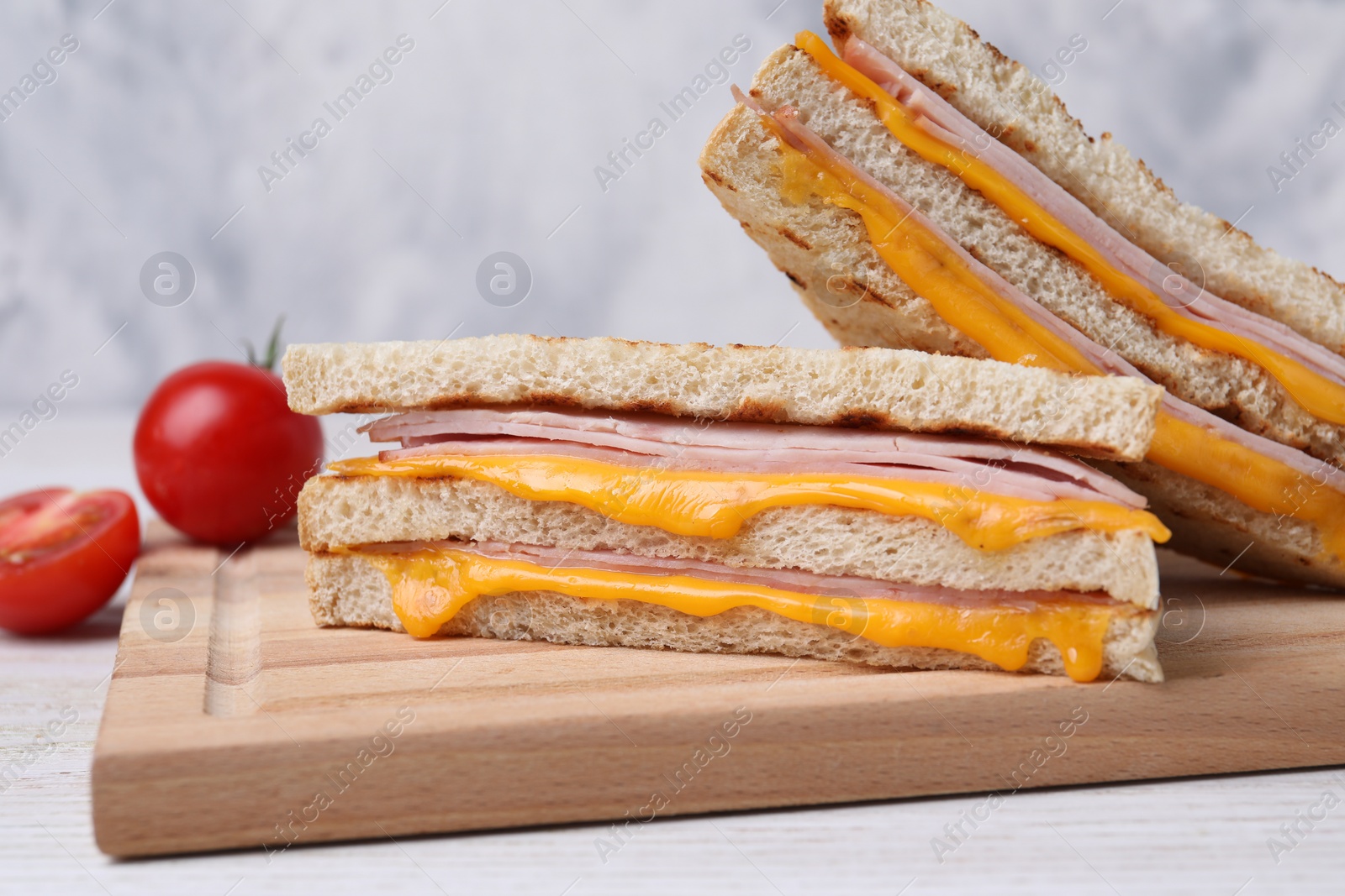 Delicious grilled sandwiches with ham and cheese on white table, closeup Photo of Delicious grilled sandwiches with ham and cheese on white table, closeup