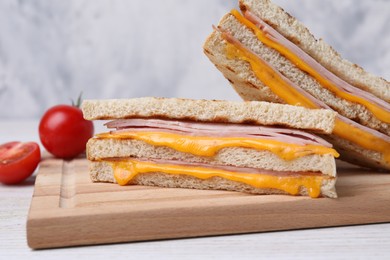 Photo of Delicious grilled sandwiches with ham and cheese on white table, closeup