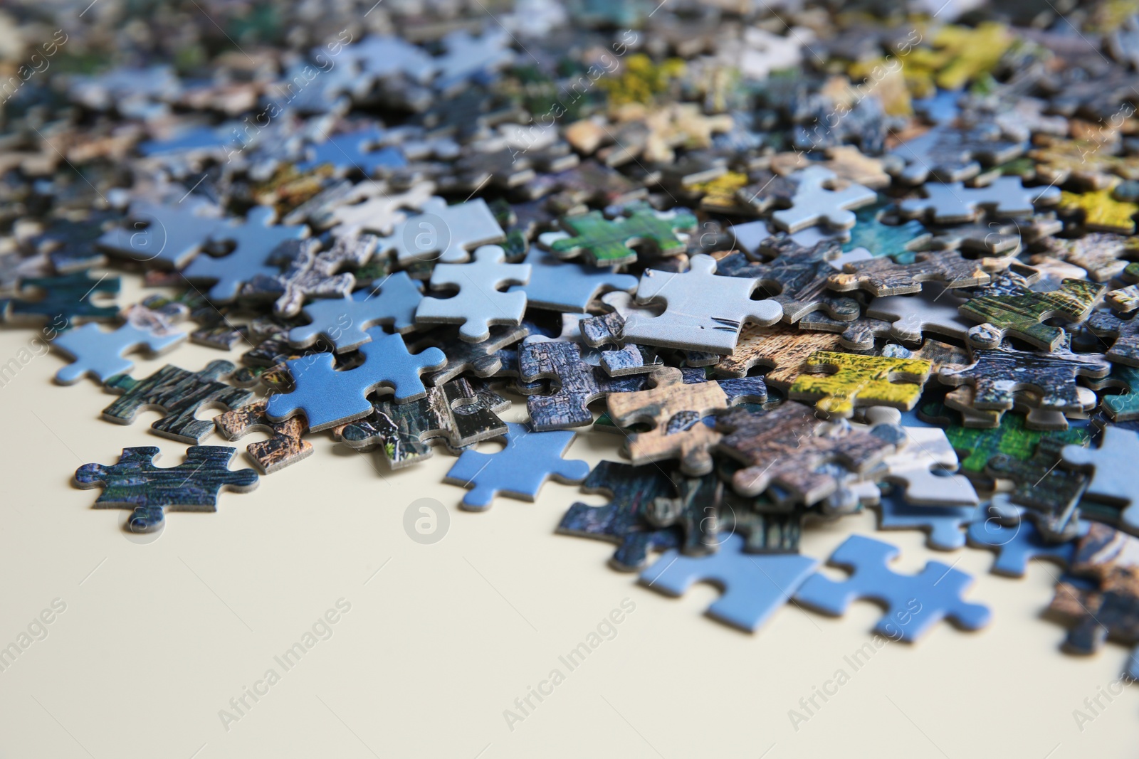 Photo of Puzzle pieces on white table, closeup view