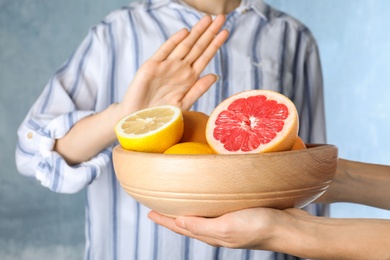 Photo of Woman refusing to eat citrus fruits, closeup. Food allergy concept