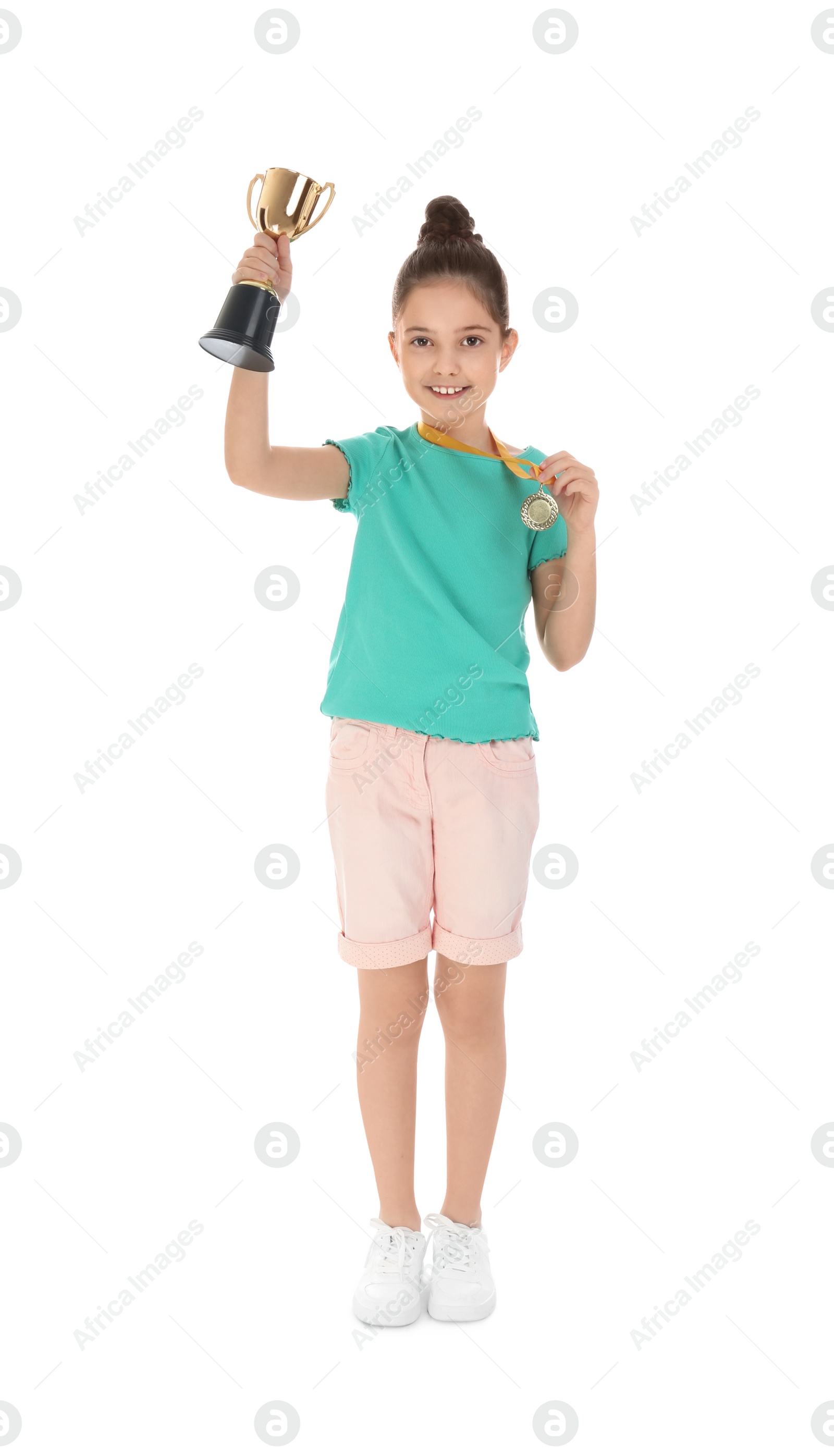 Photo of Happy girl with golden winning cup and medal isolated on white