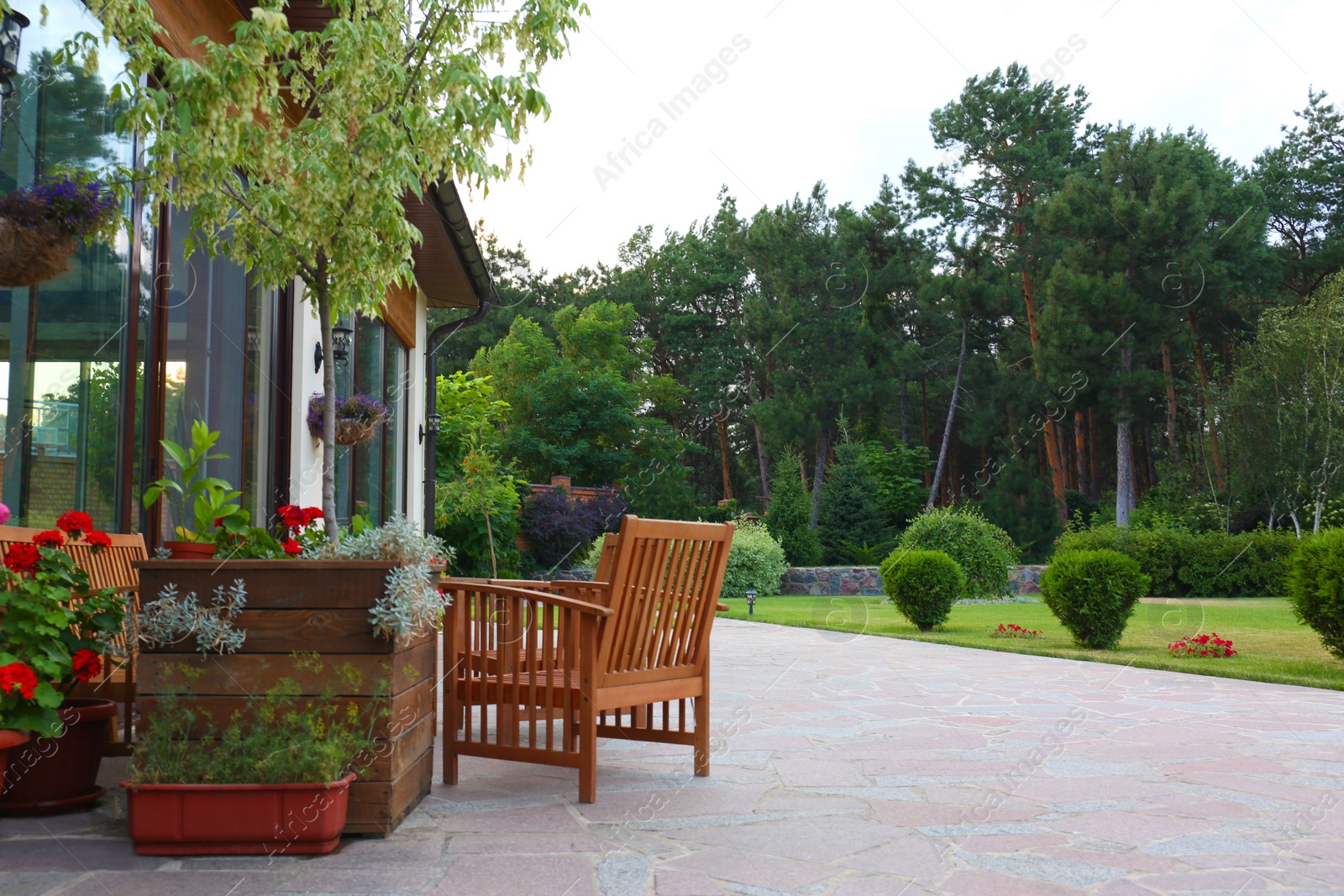 Photo of Wooden garden furniture on backyard near modern house