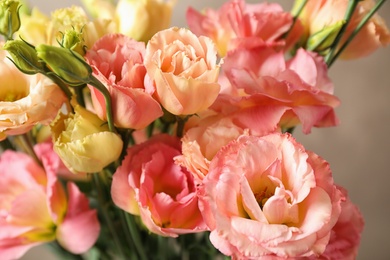 Photo of Beautiful Eustoma flowers against beige background, closeup