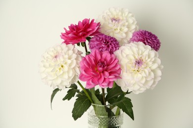 Bouquet of beautiful Dahlia flowers near white wall, closeup