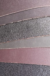 Photo of Many sheets of sandpaper as background, top view