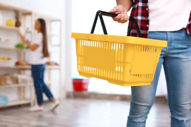 Photo of Man with empty shopping basket in grocery store, closeup