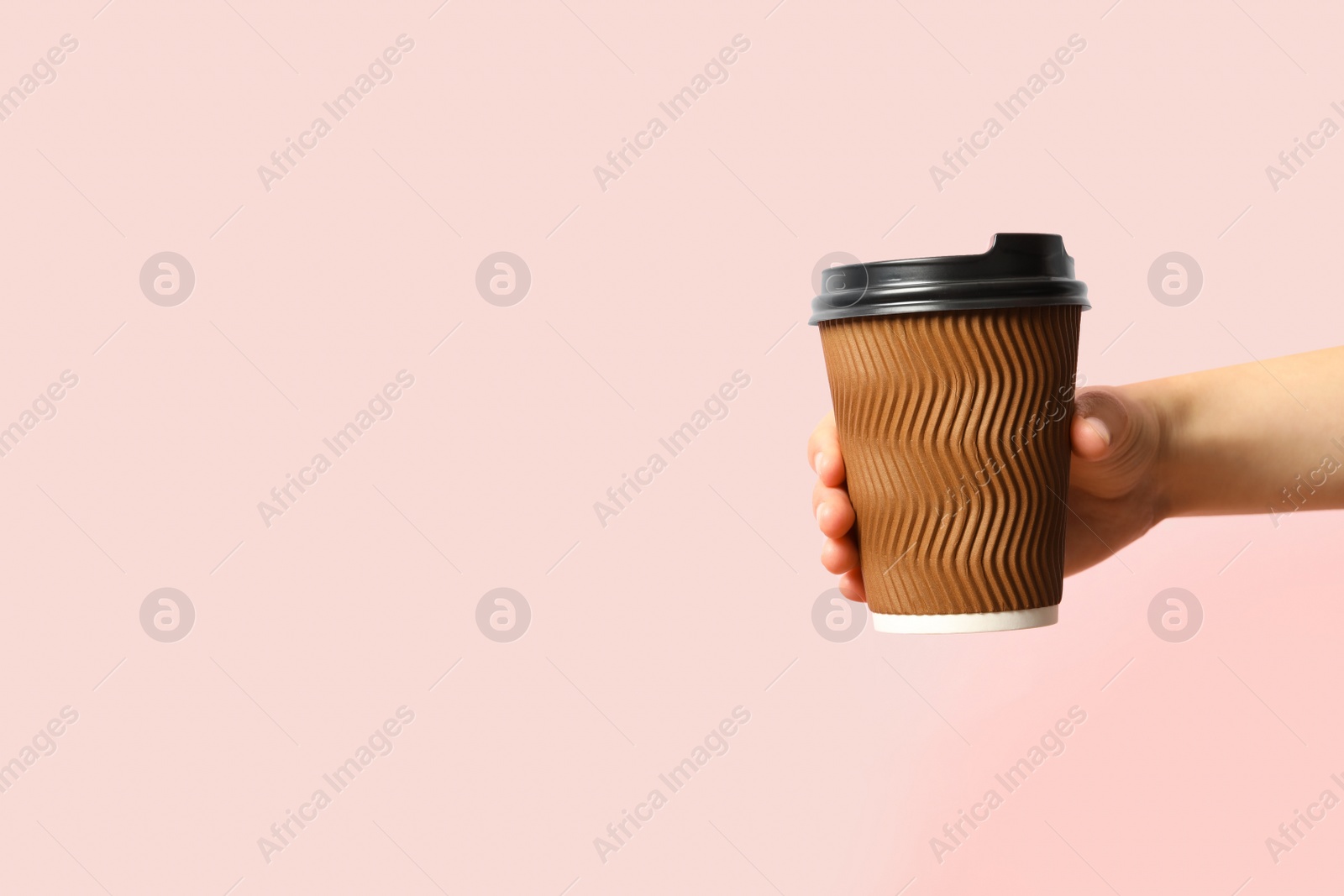 Photo of Woman holding takeaway paper coffee cup on pink background, closeup. Space for text