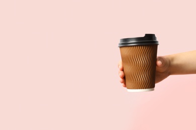 Photo of Woman holding takeaway paper coffee cup on pink background, closeup. Space for text