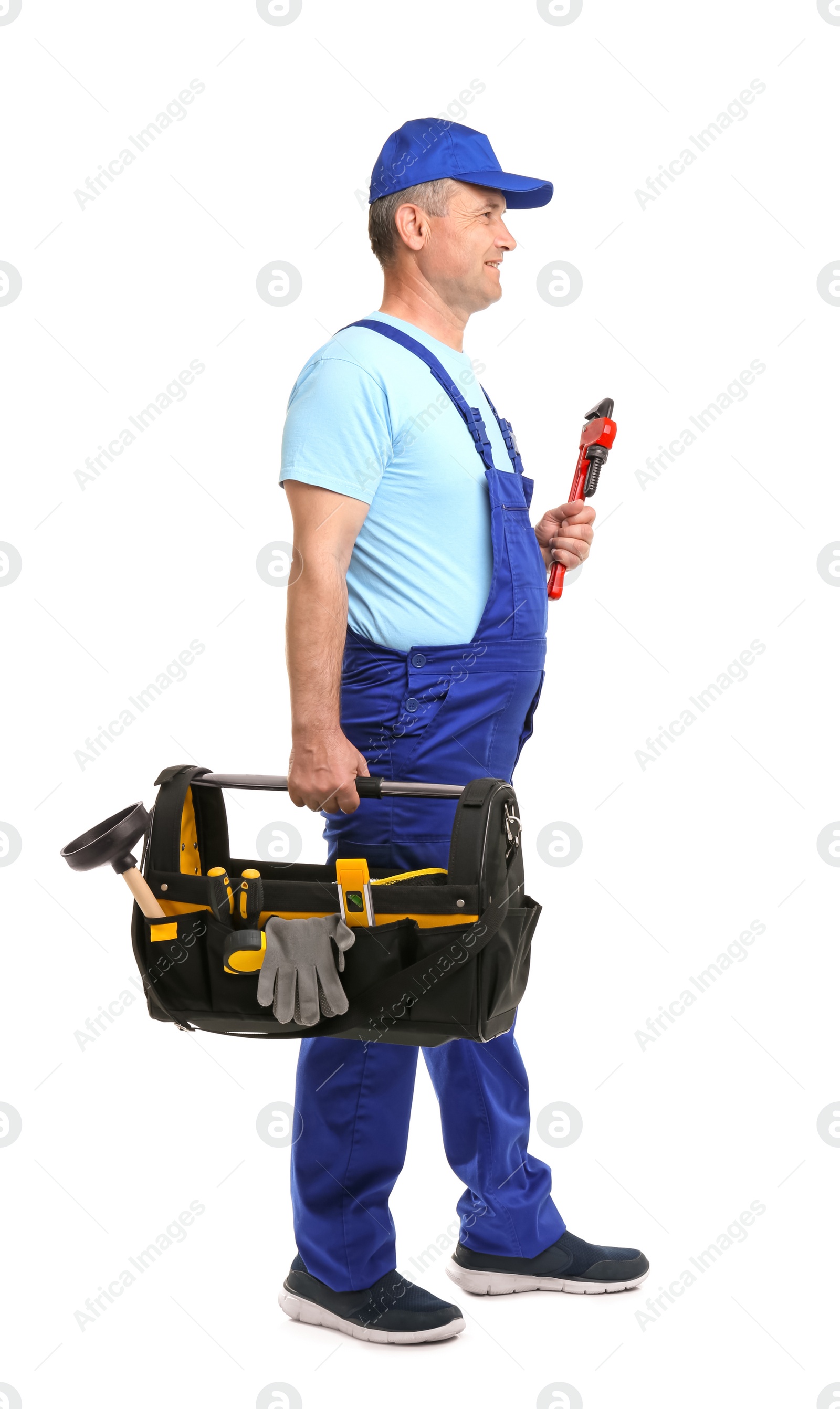 Photo of Mature plumber with pipe wrench and tool bag on white background