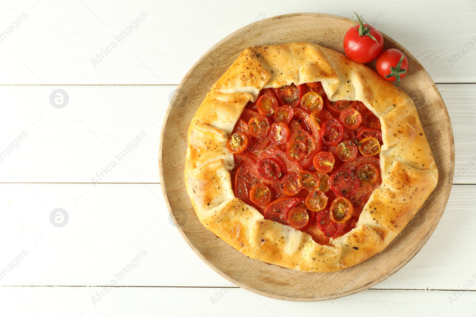 Photo of Tasty tomato galette (Caprese galette) on white wooden table, top view. Space for text