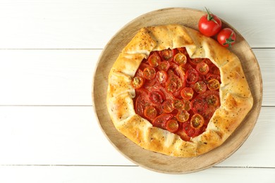 Photo of Tasty tomato galette (Caprese galette) on white wooden table, top view. Space for text