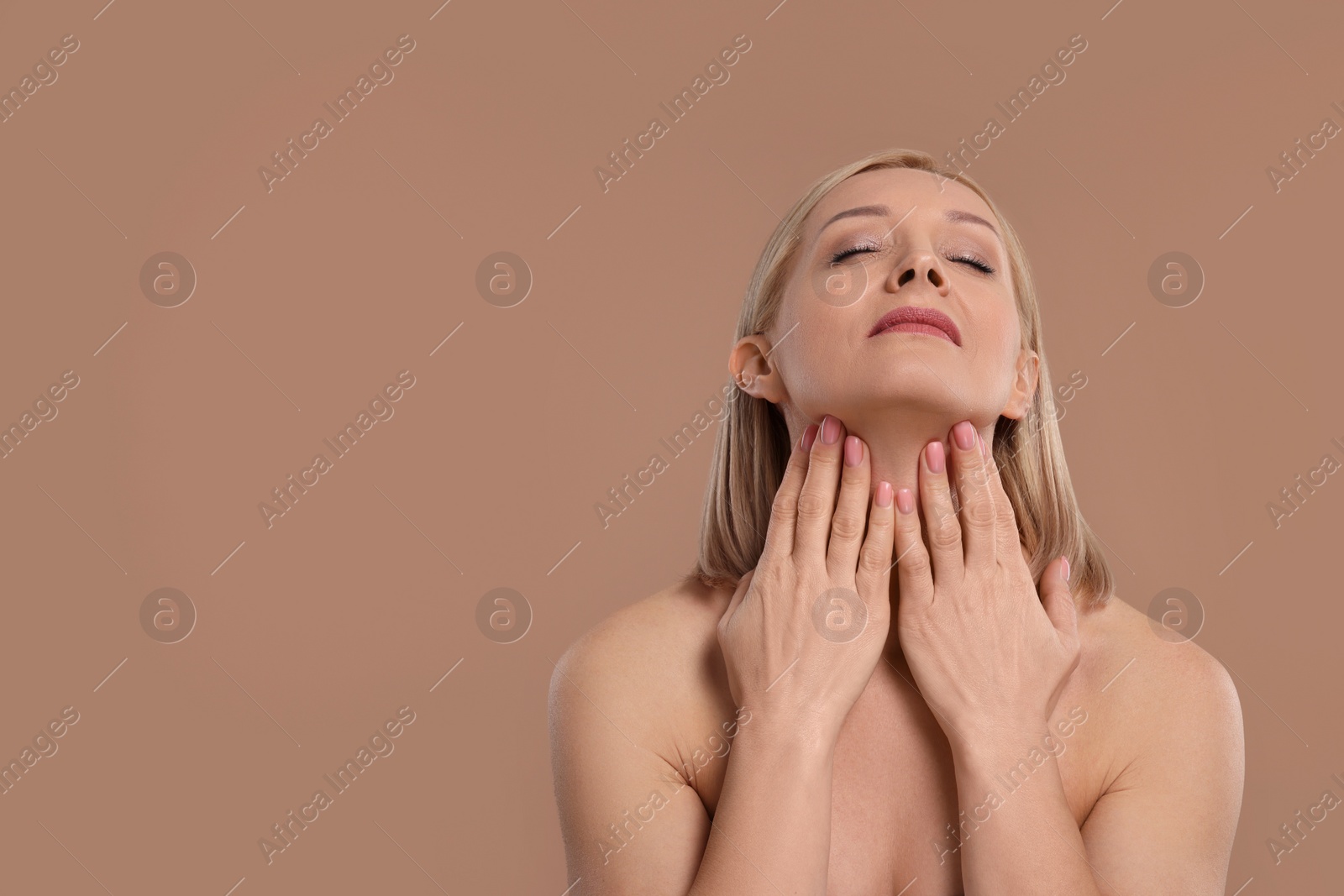 Photo of Beautiful woman touching her neck on beige background, space for text