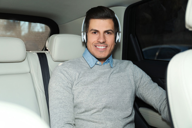 Photo of Handsome man listening to audiobook in car