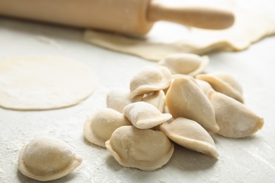 Photo of Raw dumplings on light background, closeup. Process of cooking