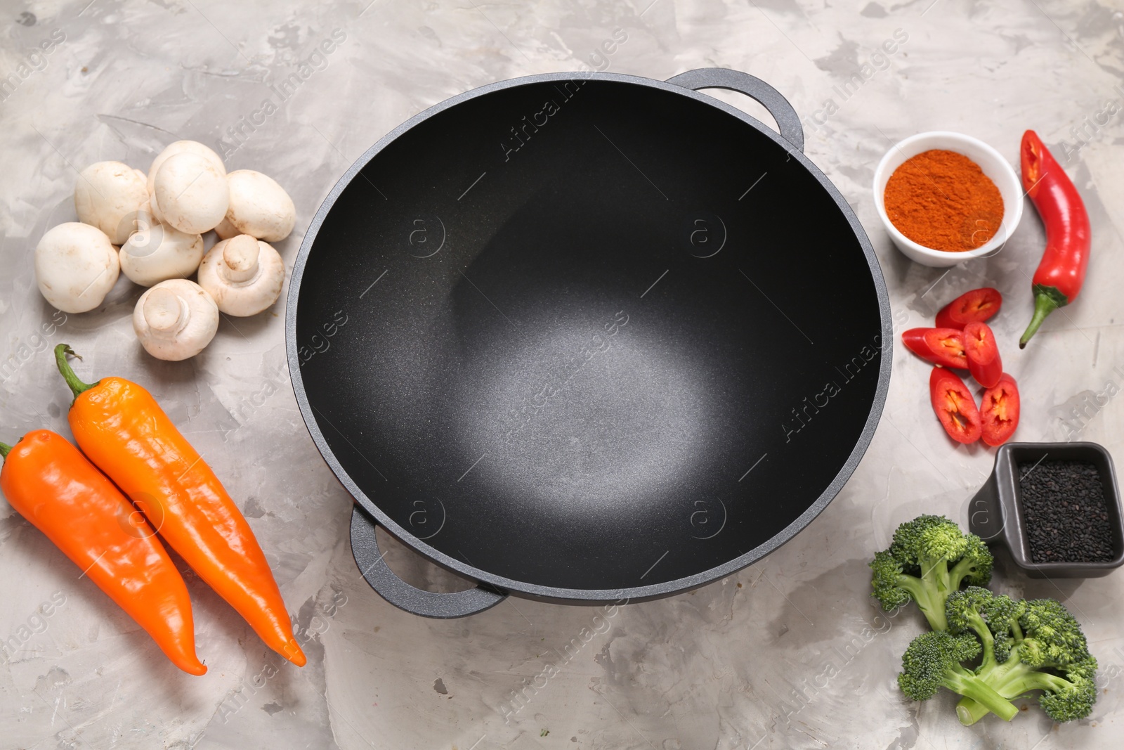 Photo of Wok and different products on grey textured table