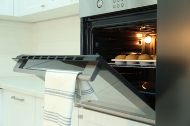 Baking pan with cupcakes in modern oven