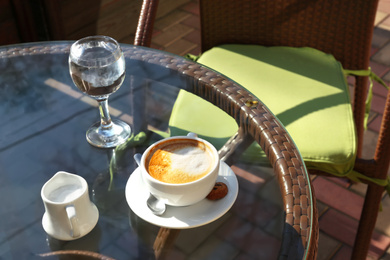 Photo of Cup of fresh aromatic coffee at table in cafe