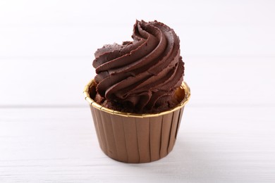 Photo of Delicious chocolate cupcake on white wooden table, closeup