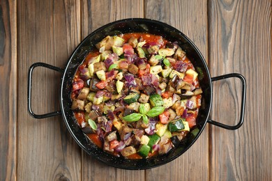 Photo of Delicious ratatouille in baking dish on wooden table, top view