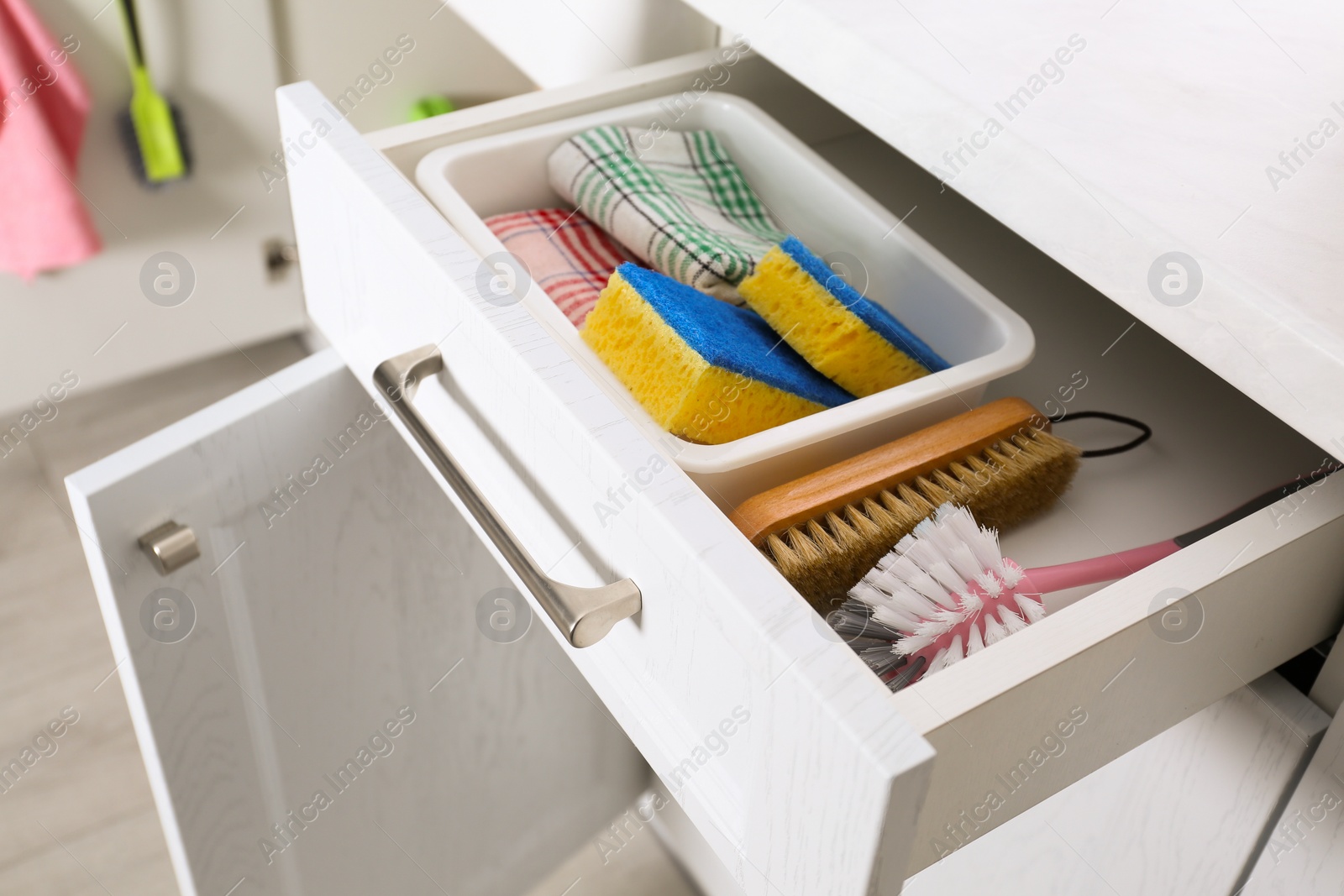 Photo of Different cleaning supplies in open drawer indoors