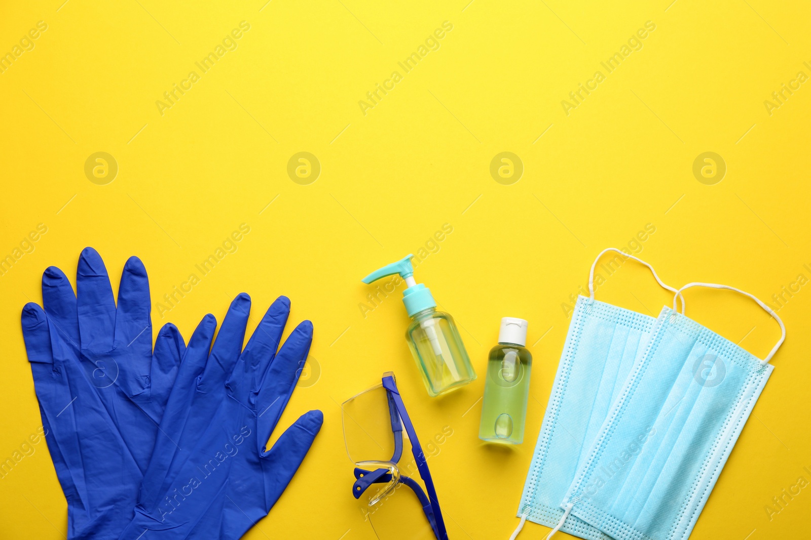 Photo of Flat lay composition with medical gloves, masks and hand sanitizers on yellow background. Space for text