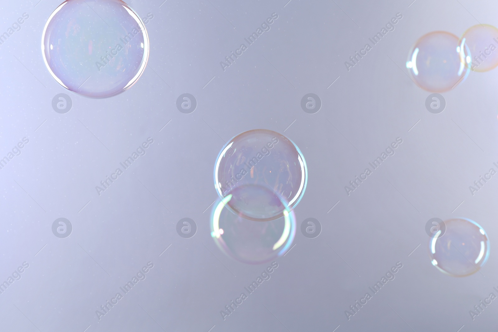 Photo of Beautiful transparent soap bubbles on gray background