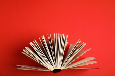 Hardcover book on red background, top view
