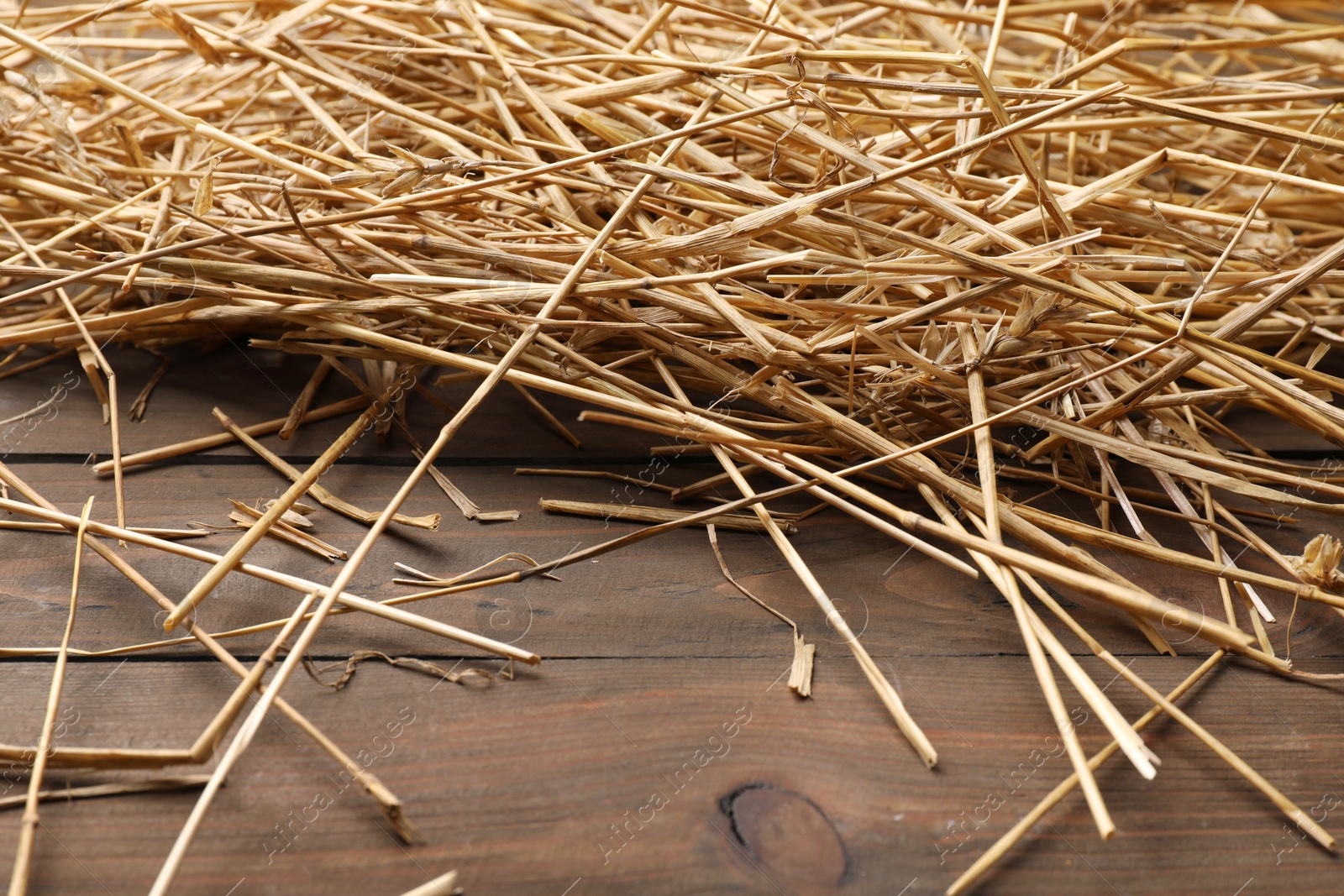 Photo of Pile of dried straw on wooden table