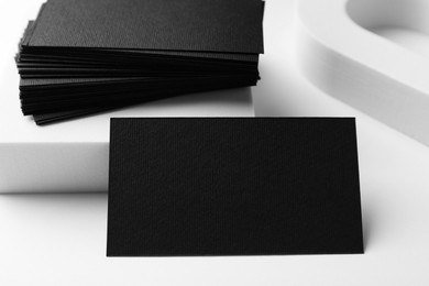 Photo of Blank black business cards on white background, closeup. Mockup for design