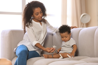 African-American woman with her baby in living room. Happiness of motherhood