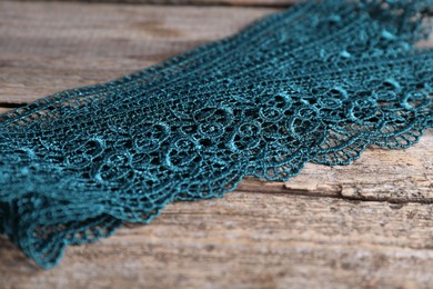 Photo of Beautiful lace on wooden table, closeup view