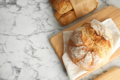 Flat lay composition with fresh bread and space for text on marble table