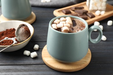 Photo of Cup of aromatic hot chocolate with marshmallows on dark gray wooden table, closeup