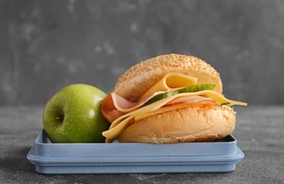 Photo of Lunch box with tasty food on gray background