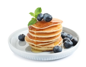 Plate of tasty pancakes with blueberries, honey and mint on white background