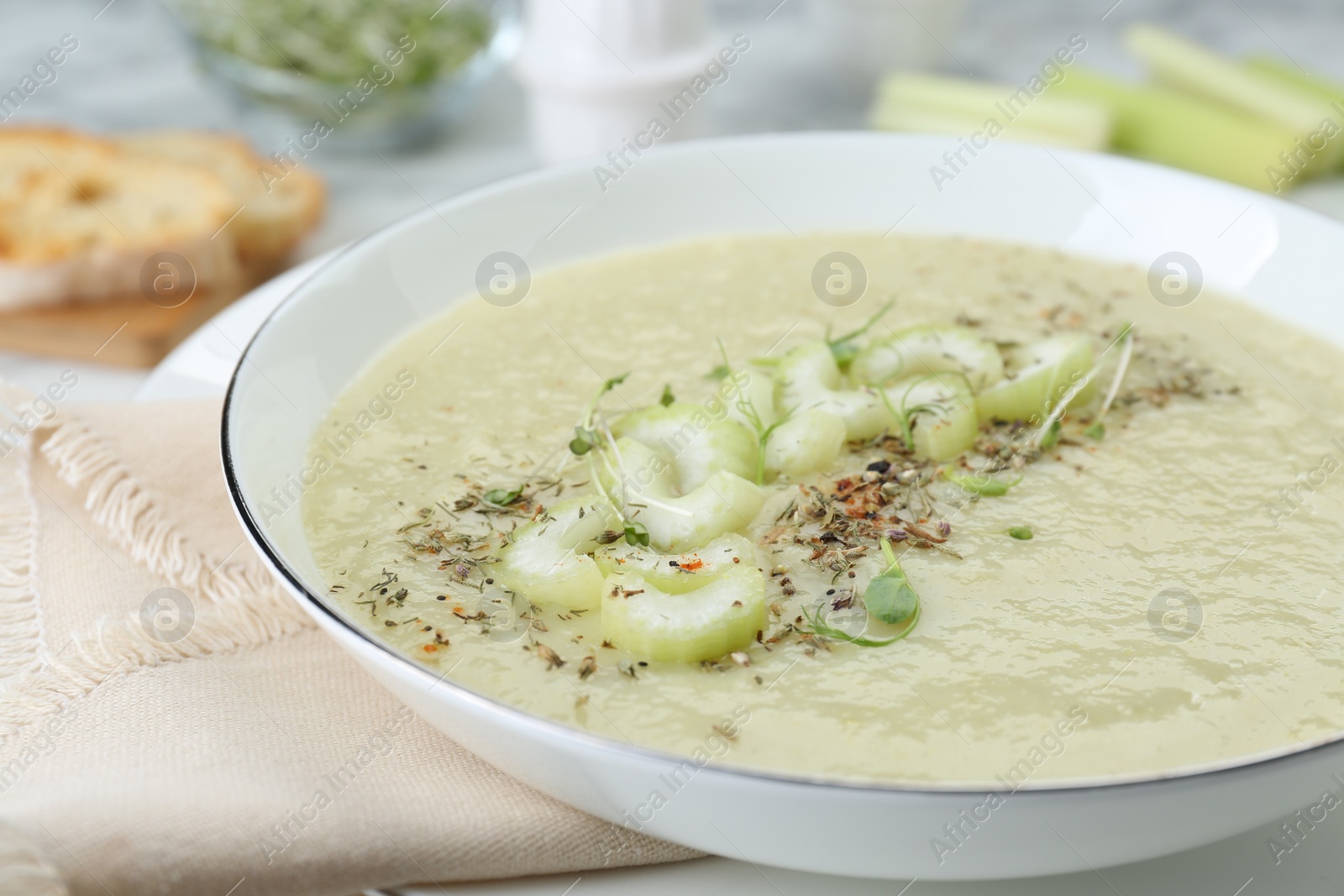 Photo of Bowl of delicious celery soup on table, closeup
