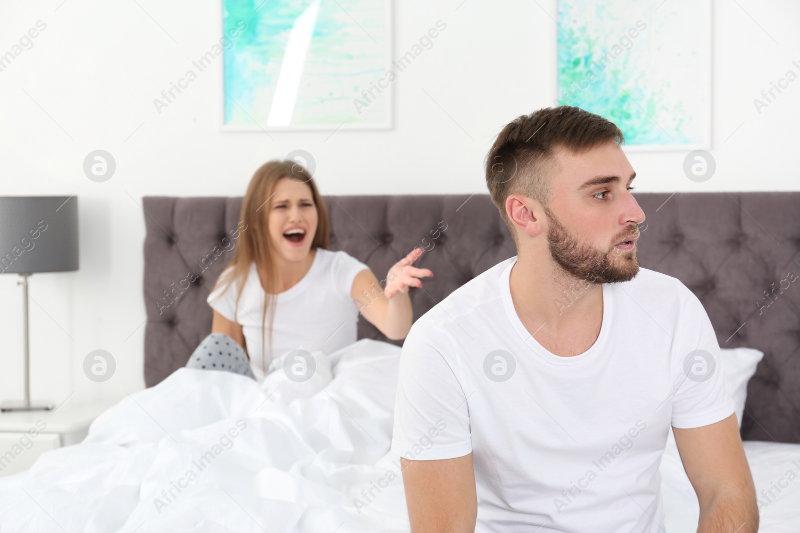 Photo of Young couple arguing in bedroom. Relationship problems