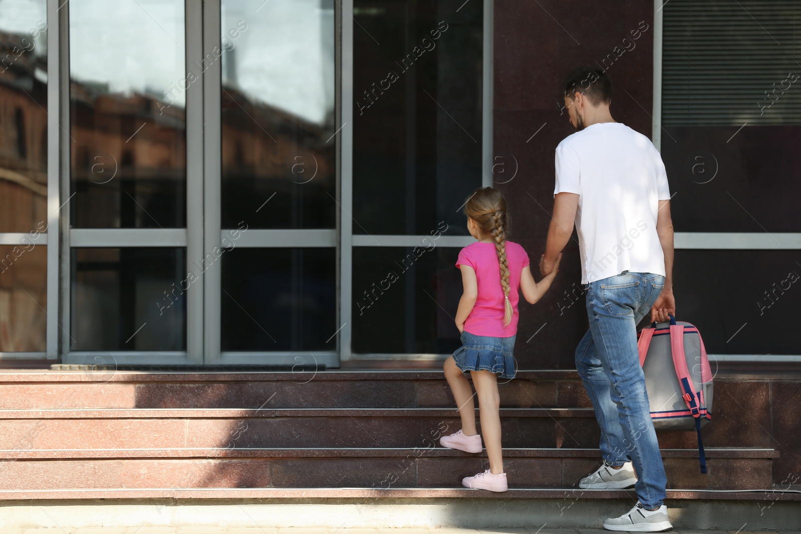 Photo of Little girl with her father on way to school