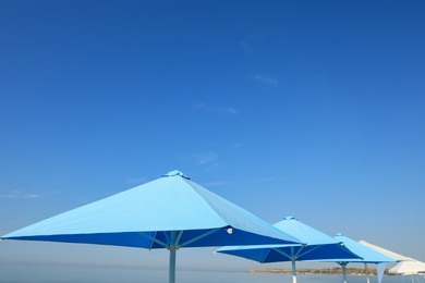 Bright beach umbrellas against blue sky on sunny day