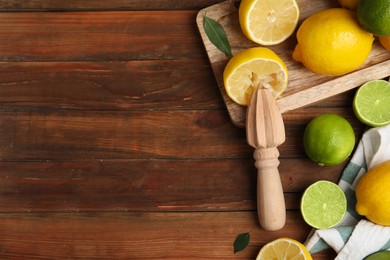Photo of Squeezer with lemons on wooden table, flat lay. Space for text