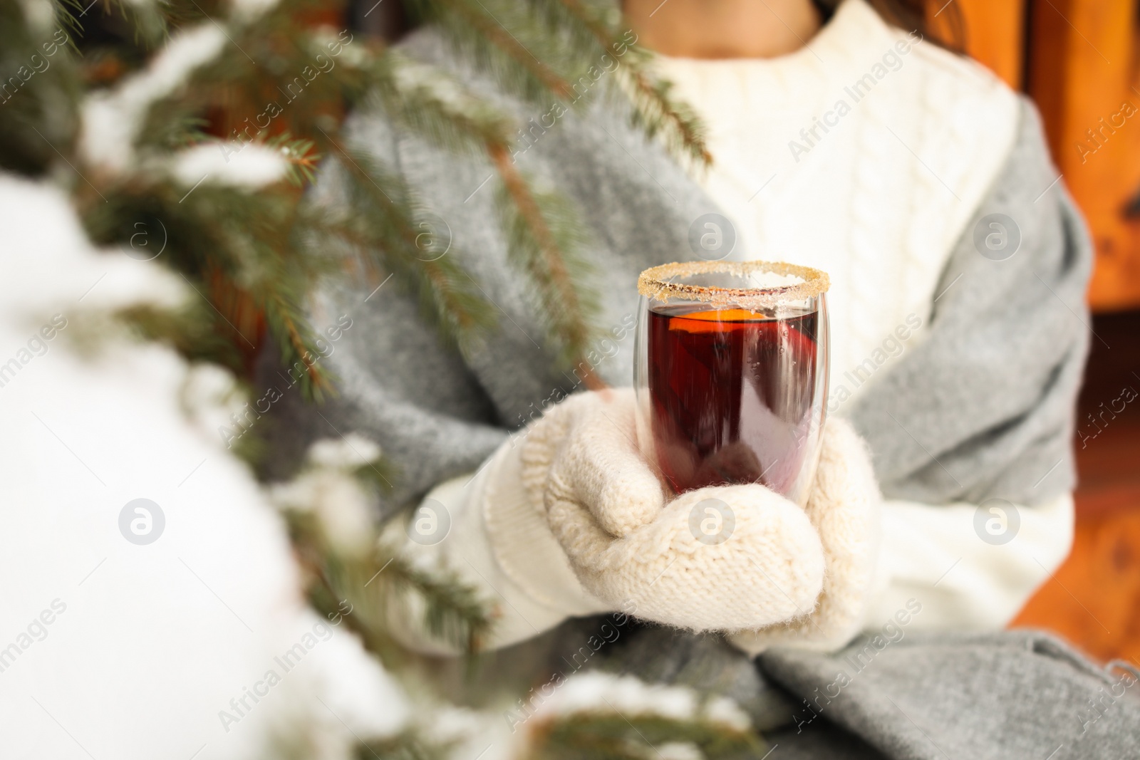 Photo of Woman with tasty mulled wine outdoors, closeup