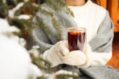 Photo of Woman with tasty mulled wine outdoors, closeup